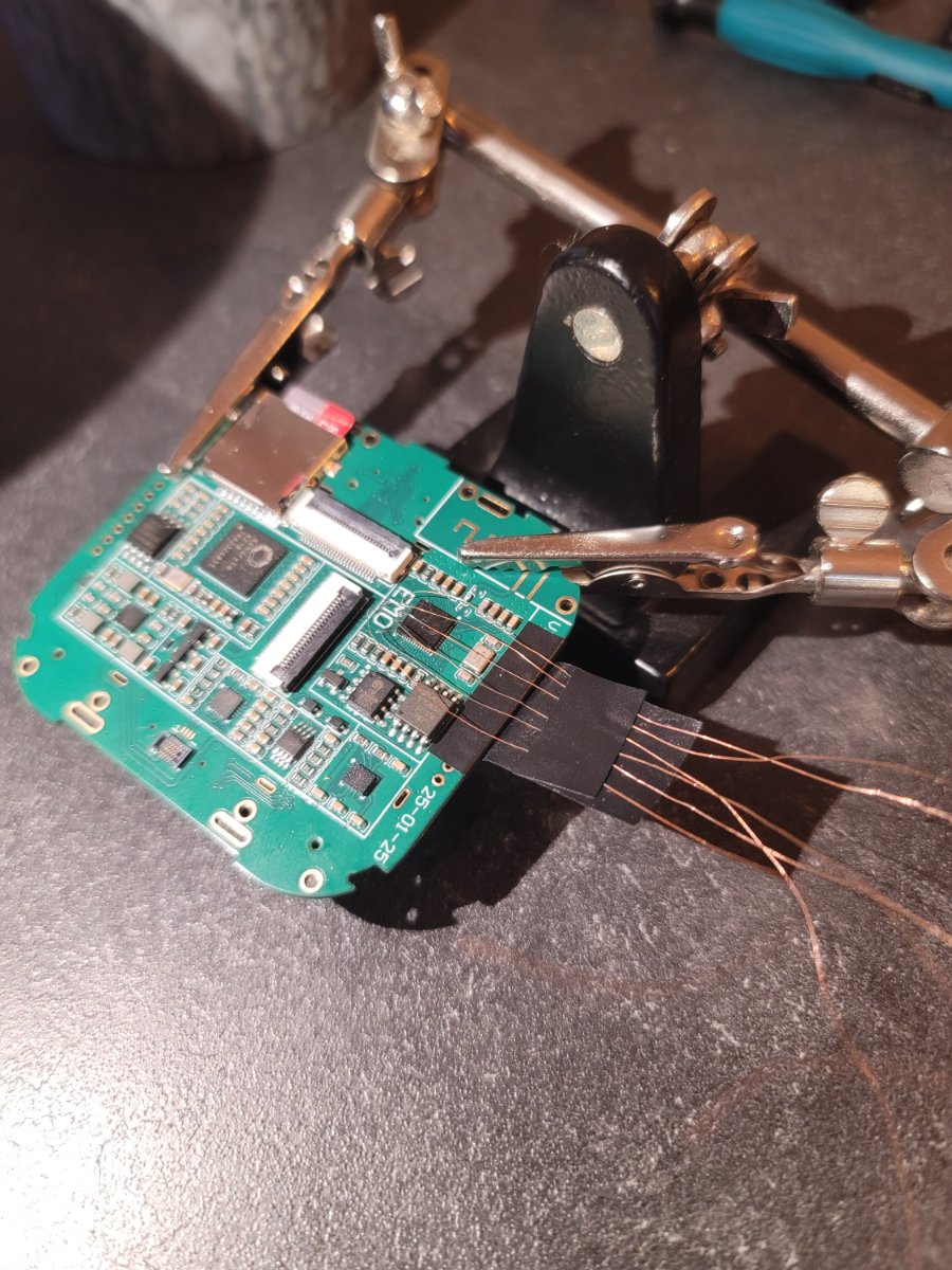 The robot's mainboard held in a helping-hands rig, hair-thin wires soldered out to the logic analyser.