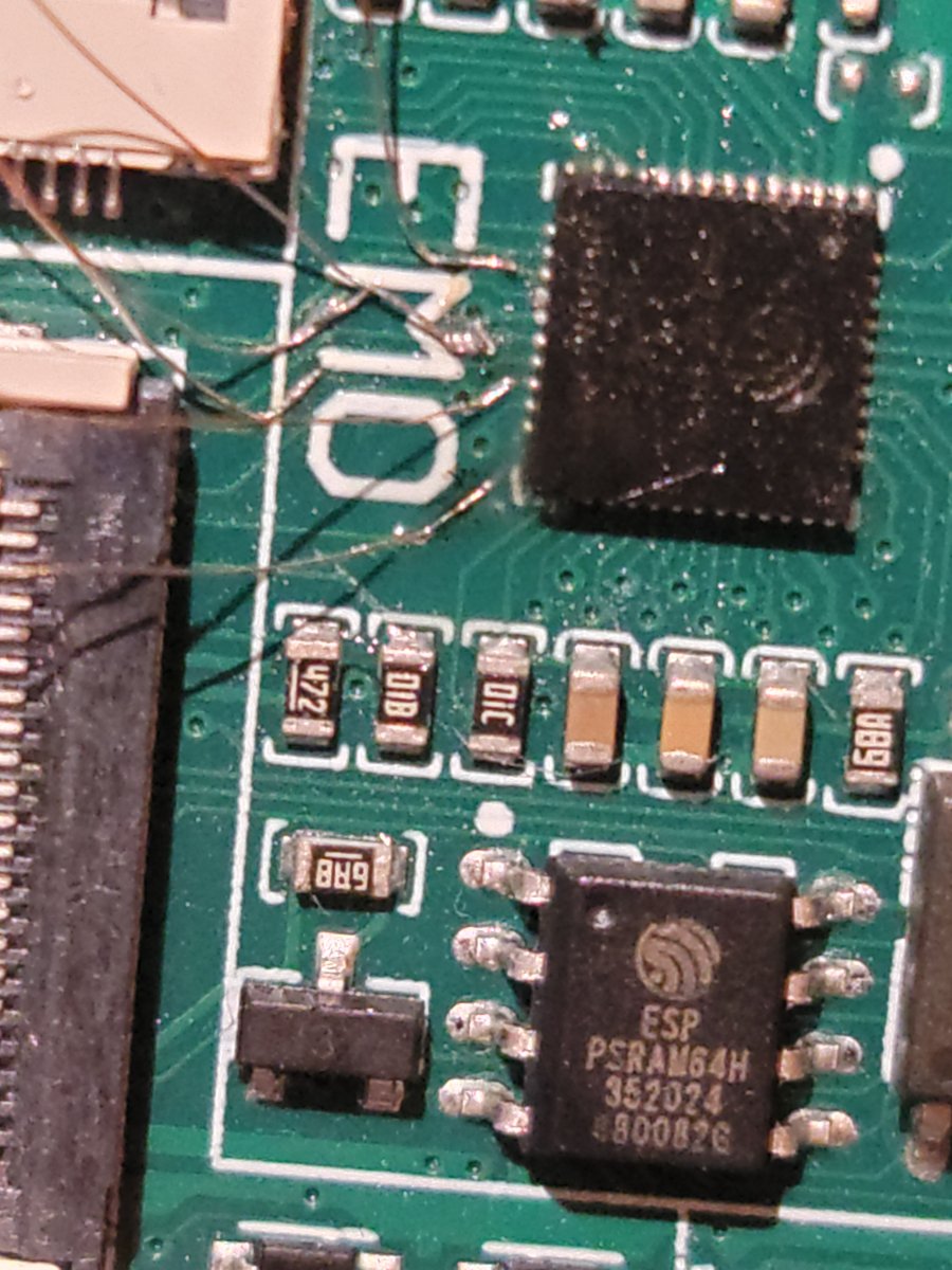 Macro of the EMO board — hair-thin taps soldered beside the ESP32 module and the ESP PSRAM64H.