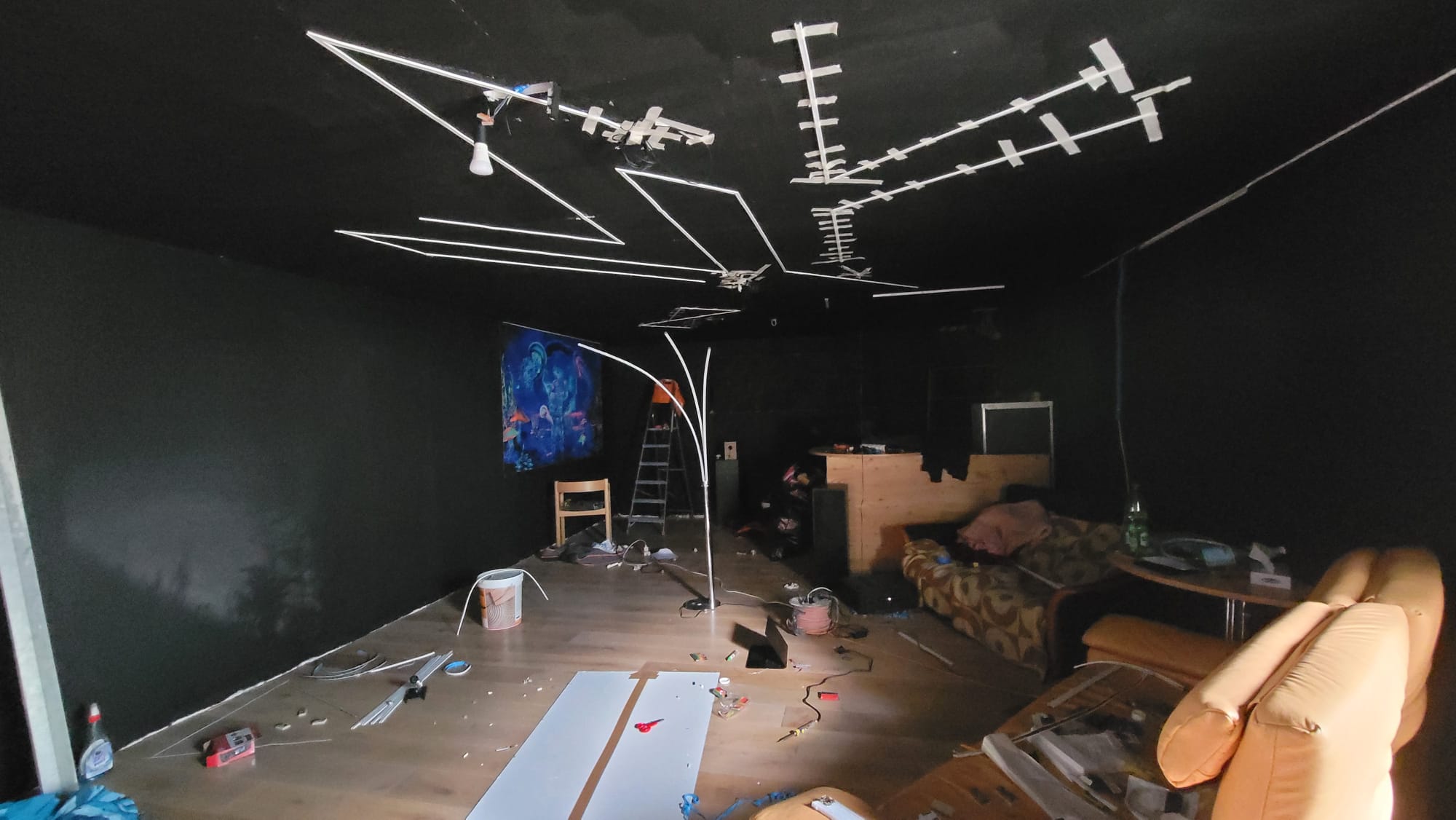 Ceiling blacked out, the LED strip geometry taped out mid-install.